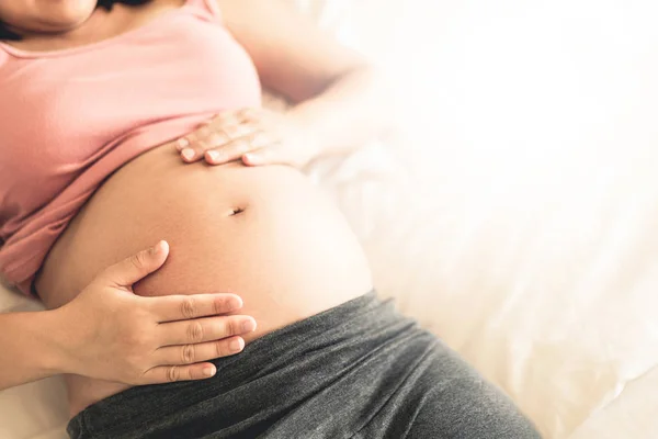 Mujer embarazada feliz y esperando un bebé en casa. — Foto de Stock