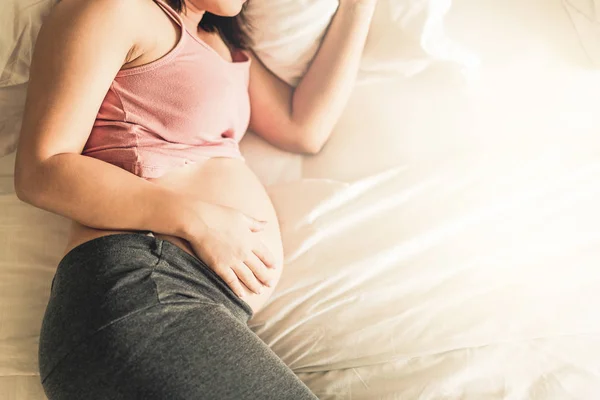 Mujer embarazada feliz y esperando un bebé en casa. — Foto de Stock