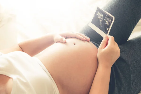 Mujer embarazada feliz y esperando un bebé en casa. — Foto de Stock