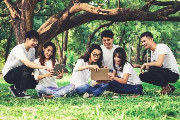 Team of young students studying in the park.