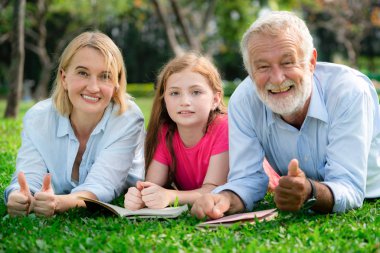 Mutlu aile park bahçesinde birlikte kitap okudu.