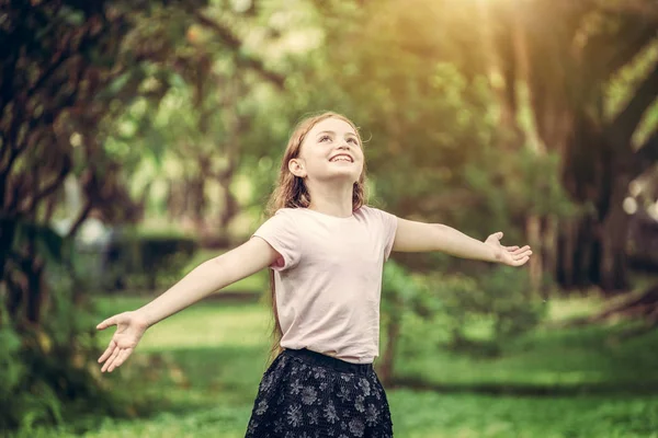 Fröhliche süße kleine Mädchen spielen im Park. — Stockfoto