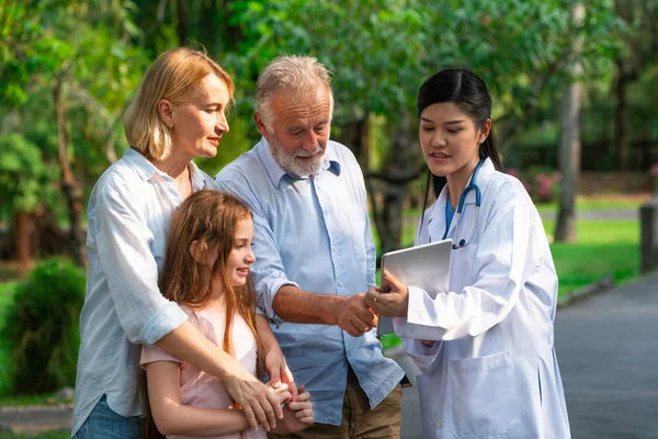 Heureux en bonne santé famille et médecin parlant dans le parc . — Photo