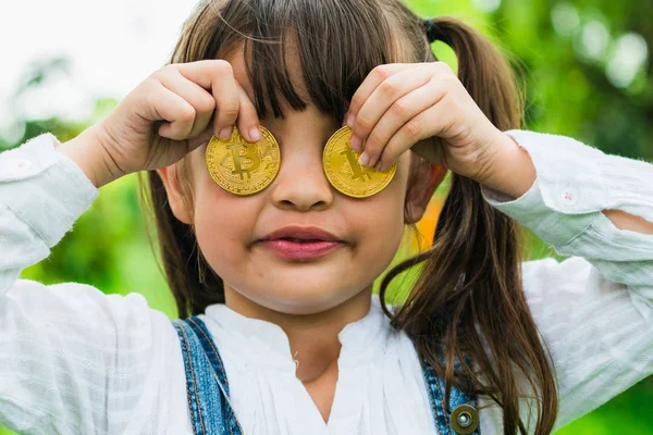 Kleines Mädchen im Besitz von digitalem Bitcoin-Geld. — Stockfoto