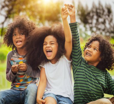 Okulda parkta oynayan mutlu çocuklar grubu.