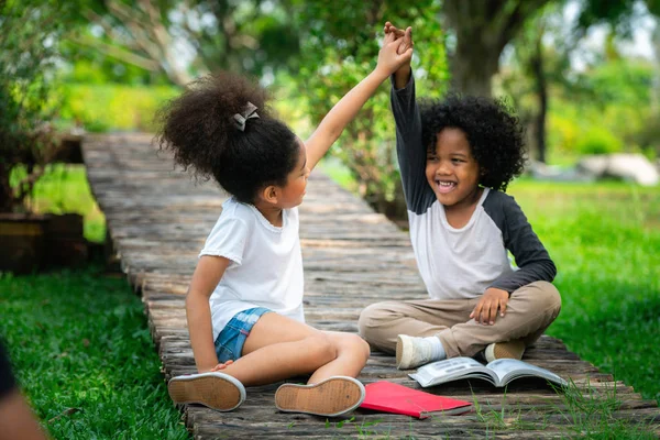 Glad liten pojke och flicka i parken. — Stockfoto