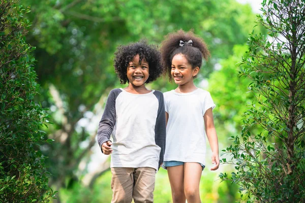 Glad liten pojke och flicka i parken. — Stockfoto