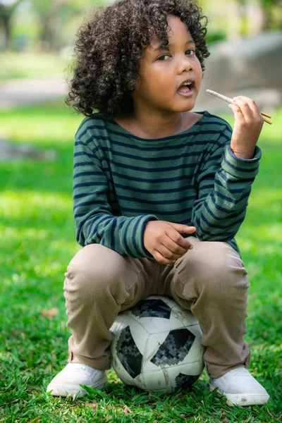 Feliz afroamericano niño comiendo snack stick . — Foto de Stock