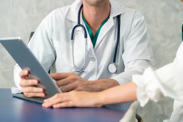 Jovem médico examinando paciente em consultório hospitalar . — Fotografia de Stock