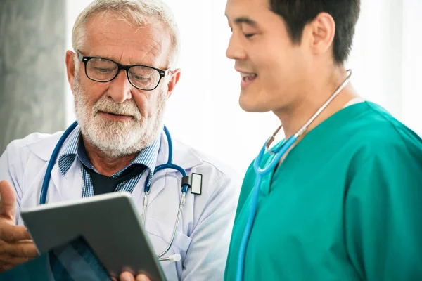 Senior male doctor working with another doctor.