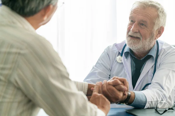 Старший врач разговаривает с пациентом в больнице . — стоковое фото