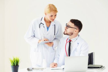 Hastanedeki doktor ortağıyla bilgisayar başında çalışıyor.