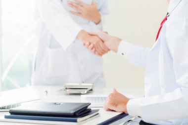 Hastanedeki doktor başka bir doktorla el sıkışıyor