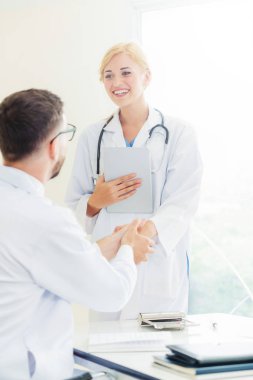 Hastanedeki doktor başka bir doktorla el sıkışıyor