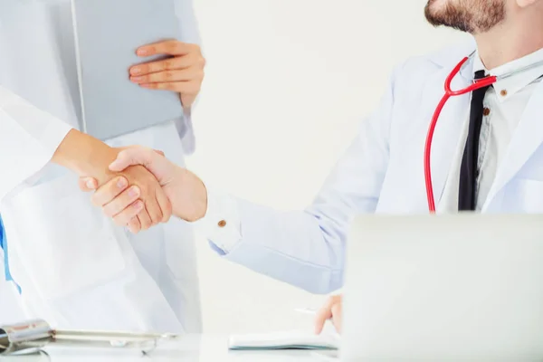 Läkare på sjukhuset skakar hand med en annan läkare — Stockfoto