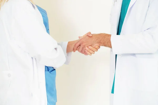 GP médico aperta a mão com médico cirúrgico . — Fotografia de Stock
