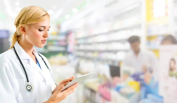 Farmacista che utilizza tablet in farmacia . — Foto Stock