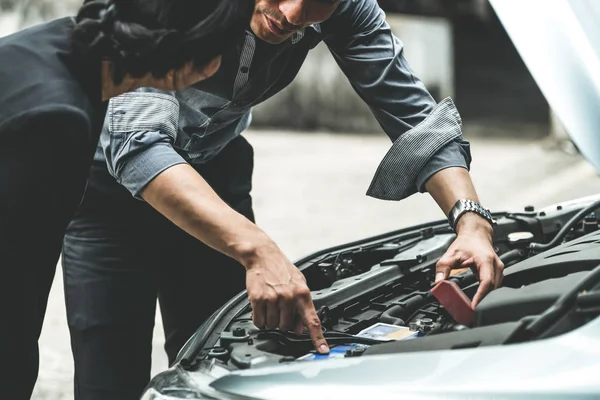 Man helpen vrouw op te lossen de auto probleem. — Stockfoto