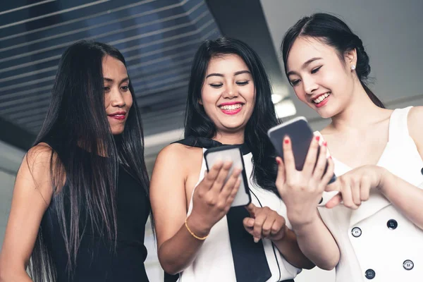 Tres mujeres amigos chatear con el dispositivo de teléfono móvil. —  Fotos de Stock