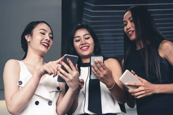 Tres mujeres amigos chatear con el dispositivo de teléfono móvil. —  Fotos de Stock
