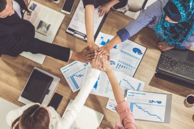 Takım çalışması çalışanları toplantıda el ele tutuşuyor.