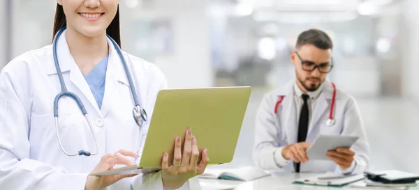 Médico que trabalha no hospital com outros médicos . — Fotografia de Stock