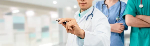 Médico que trabalha no hospital com outros médicos . — Fotografia de Stock