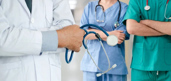 Médico que trabalha no hospital com outros médicos . — Fotografia de Stock