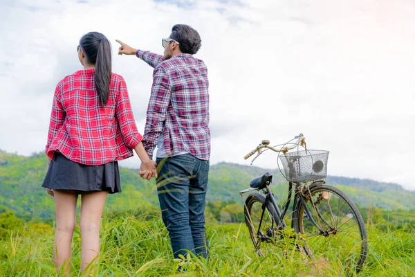 幸福的年轻夫妇骑自行车在山上. — 图库照片