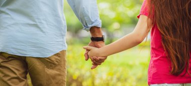 Baba ve kız parkta elele.