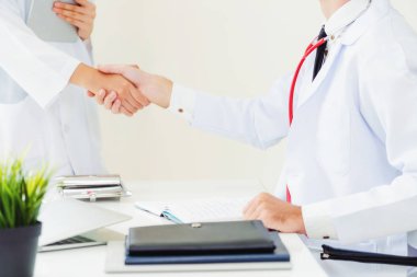 Hastanedeki doktor başka bir doktorla el sıkışıyor