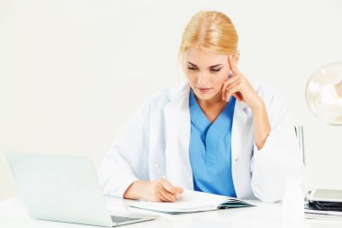 Hastanede tıbbi rapor üzerinde çalışan doktor.