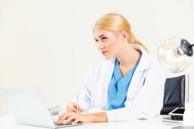 Hastanede tıbbi rapor üzerinde çalışan doktor.