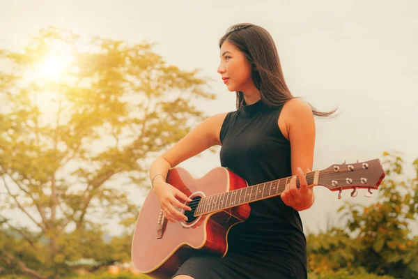 Mulher feliz toca guitarra com fundo natureza . — Fotografia de Stock