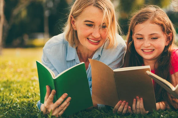 Glückliche Familie liest gemeinsam Bücher im Park. — Stockfoto