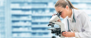 Bilim adamı araştırmacı laboratuvarda mikroskop kullanır