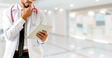 Hastanede tablet bilgisayar kullanan bir doktor..