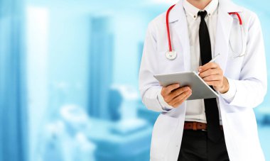 Hastanede tablet bilgisayar kullanan bir doktor..