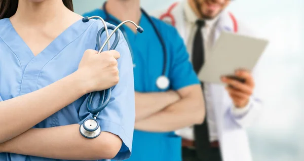 Médico que trabalha no hospital com outros médicos . — Fotografia de Stock