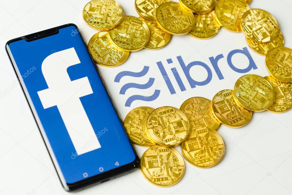 Bangkok, Thailand - July 2, 2019: Phone with Facebook logo on screen is placed on paper with Libra logo. Facebook reported to utilize new cryptocurrency called Libra expected to be used on Facebook.
