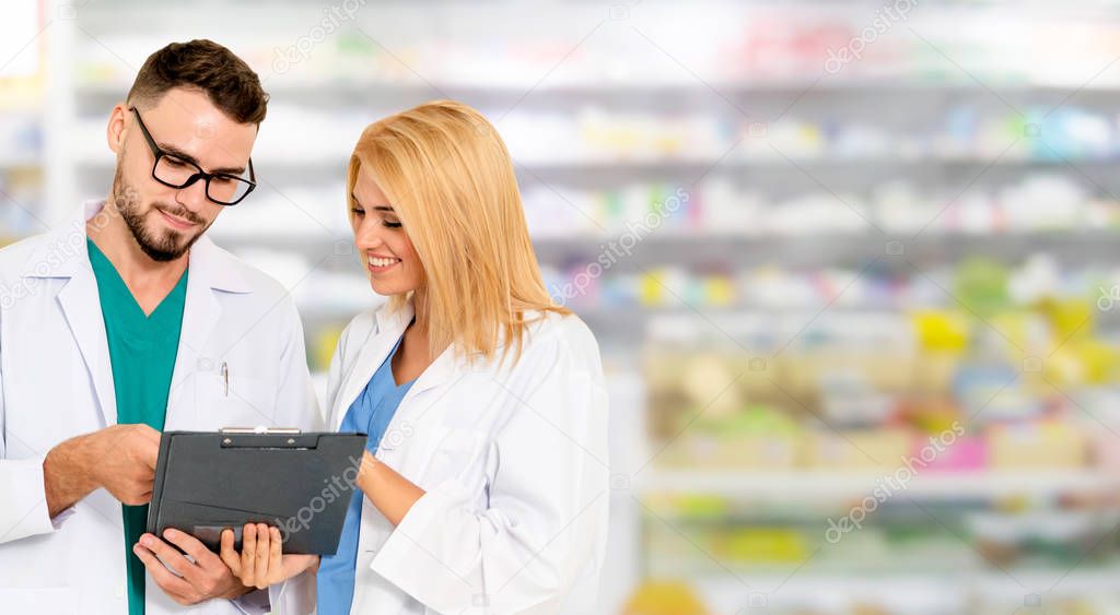 Pharmacist working with colleague in pharmacy.
