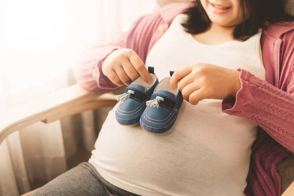 Mujer embarazada feliz y esperando un bebé en casa. — Foto de Stock