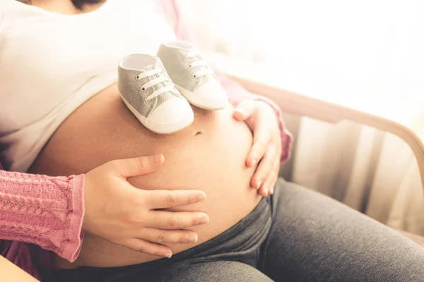 Mujer embarazada feliz y esperando un bebé en casa. —  Fotos de Stock