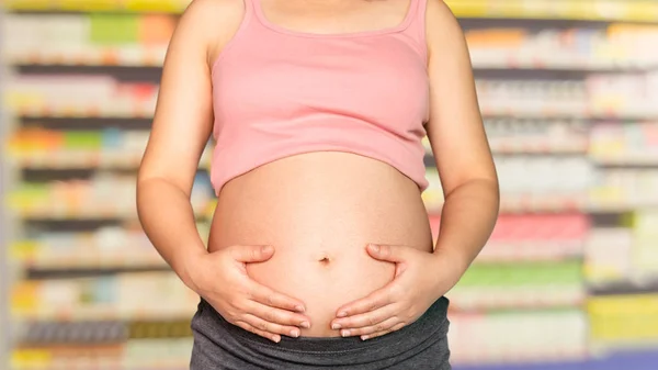 Mujer embarazada en farmacia o farmacia . —  Fotos de Stock