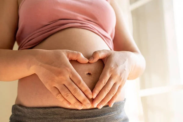 Mujer embarazada feliz y esperando un bebé en casa. — Foto de Stock