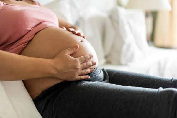 Happy pregnant woman and expecting baby at home.