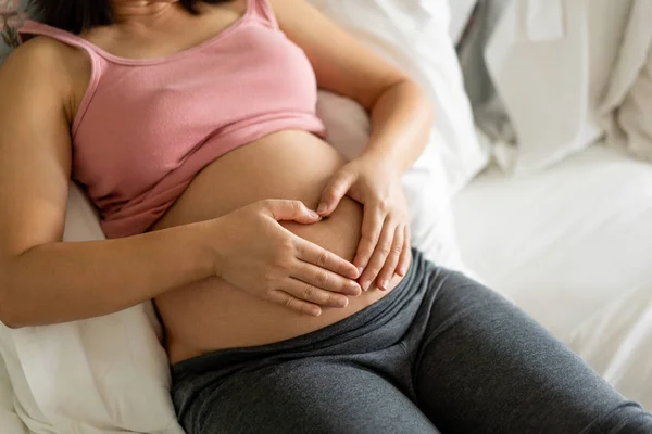 Mujer embarazada feliz y esperando un bebé en casa. — Foto de Stock