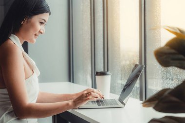 Kafede dizüstü bilgisayar kullanan iş kadını.