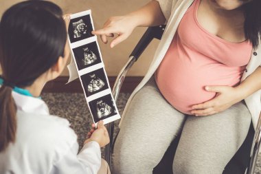 Hastanede hamile kadın ve jinekolog.