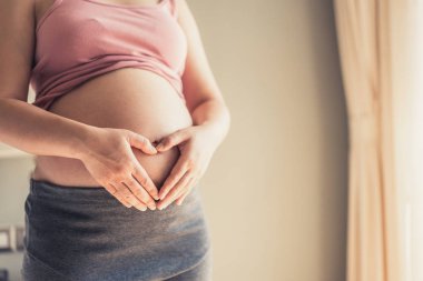 Mutlu hamile bir kadın ve evde bebek bekliyor..